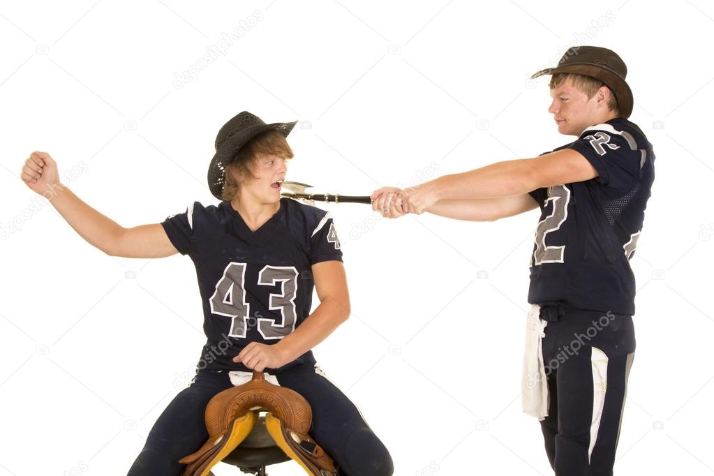 football player swinging axe at football player on saddle