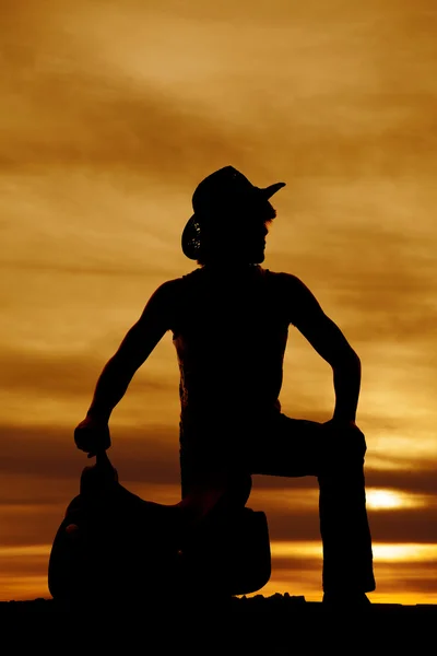 Silhouette of cowboy with saddle — Stock Photo, Image