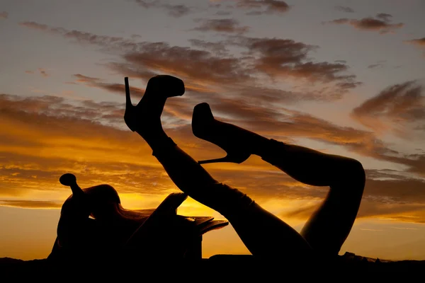 Silhouette der Frauenbeine auf dem Sattel — Stockfoto