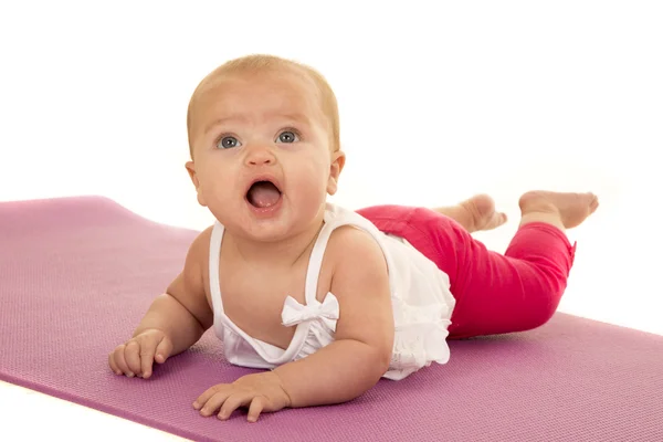 Ребенок на животе на коврике для йоги — стоковое фото