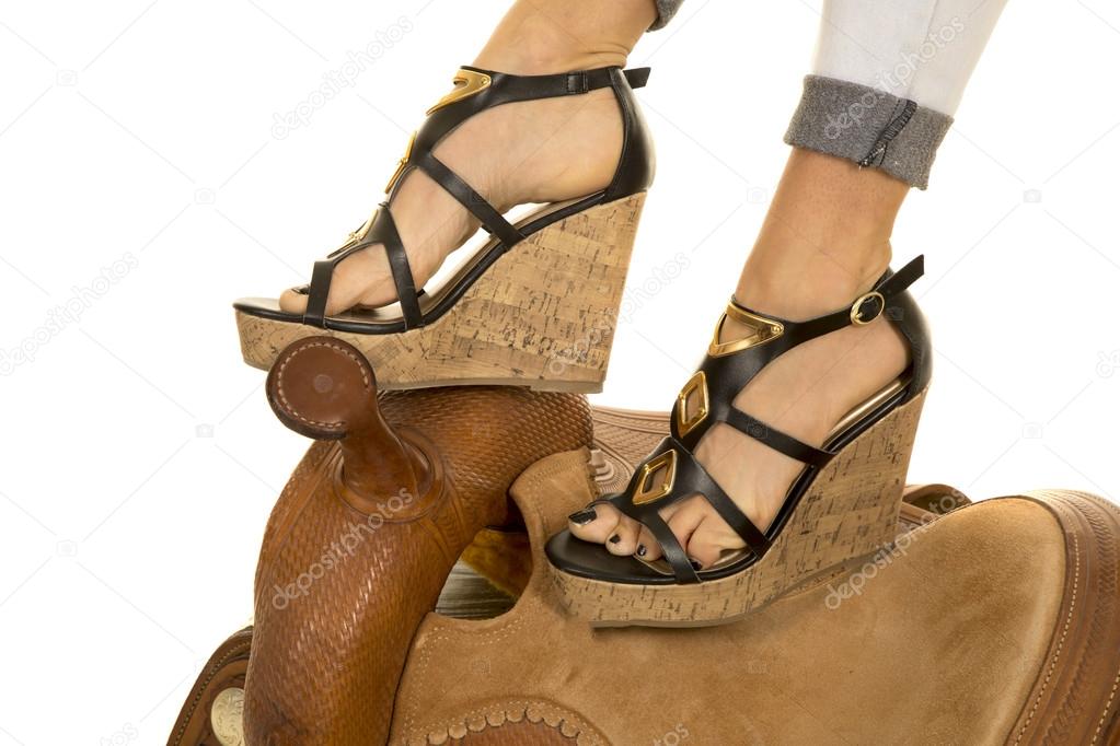 womans feet in heels on saddle