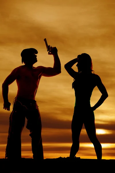 Silhouette of cowboy with gun and woman — Stock Photo, Image