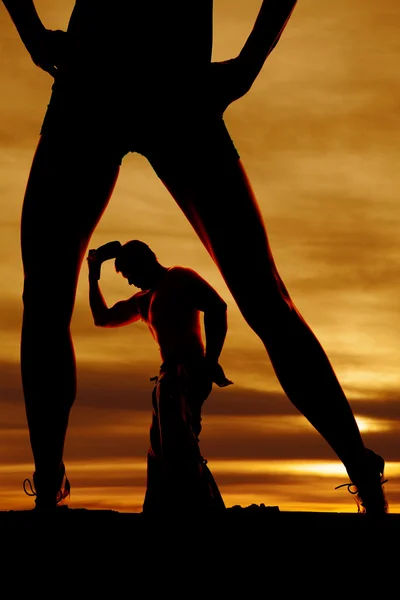 Silhouette of cowboy looking down and womans legs — Stock Photo, Image