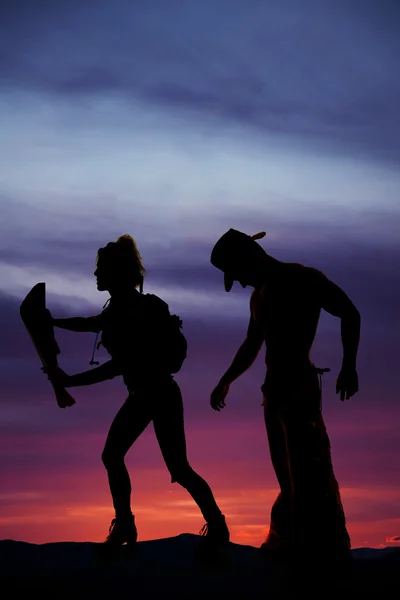 Silueta de una mujer excursionista leyendo un mapa int he sunset man behi —  Fotos de Stock