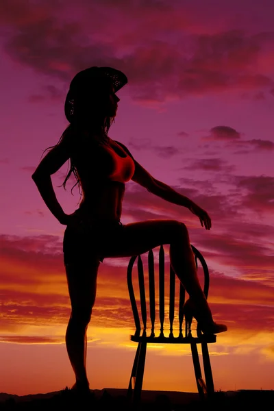 Silhouette of cowgirl foot up on chair — Stock Photo, Image