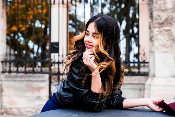 Kırmızı ve sarı sonbahar yapraklarından oluşan bir arka planda moda kadını. Autumn City Cafe 'de oturan güzel bir kız. Ekim 'de zarif bir şekilde dışarıda zaman geçiren sevimli beyaz kadın modeli..