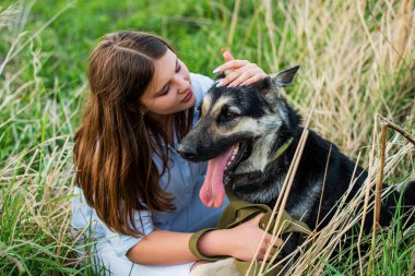 Güzel bir kadın köpeğiyle oynuyor. Açık havada portre.