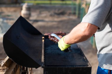 Açık havada barbekü yapan neşeli bir adamın yakın plan portresi..