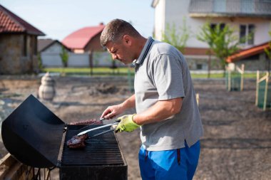 Açık havada barbekü yapan neşeli bir adamın yakın plan portresi..