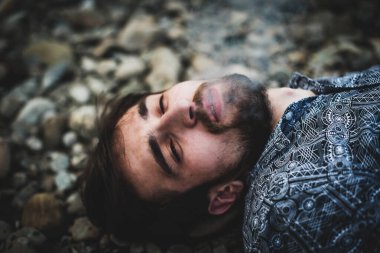 Genç, beyaz bir adam sokakta esrar tüttürüyor. Bağımlı adam iş başında. Uyuşturucu kullanımı ve trafik kavramı.