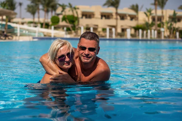 Real people concept, beautiful family, couple swimming and having fun in pool in vacation. happiness and nice body for enjoyed people live an lifestyle as vacation