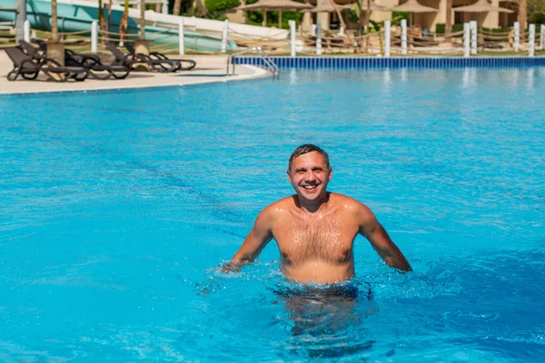 반나체의 잘생긴 남자가 수영장에서 있습니다 수영장에서 미소짓는 잘생긴 남자의 — 스톡 사진