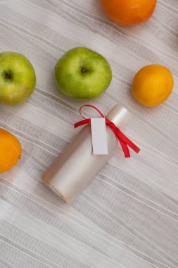 Ev yapımı kozmetik malzemelerinin resmi. Aroma temalı. Bitki özlü organik kozmetikler beyaz arka planda elma, limon ve portakallar