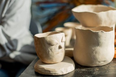 Sanat stüdyosunda işlenmemiş kil şekillendiren genç bir sanatçı. Sanatçının stüdyosundaki kil heykellerden kız kalıpları. Çömlekçisindeki iş kadını.