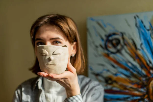 若いアーティストがアートスタジオで粘土を成形しています アーティストのスタジオで粘土彫刻から女の子の型 陶芸店で働く実業家 — ストック写真