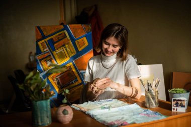 Sanat stüdyosunda işlenmemiş kil şekillendiren genç bir sanatçı. Sanatçının stüdyosundaki kil heykellerden kız kalıpları. Çömlekçisindeki iş kadını.