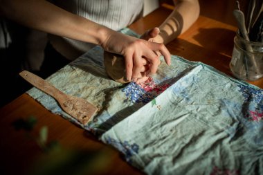 Sanat stüdyosunda işlenmemiş kil şekillendiren genç bir sanatçı. Sanatçının stüdyosundaki kil heykellerden kız kalıpları. Çömlekçisindeki iş kadını.