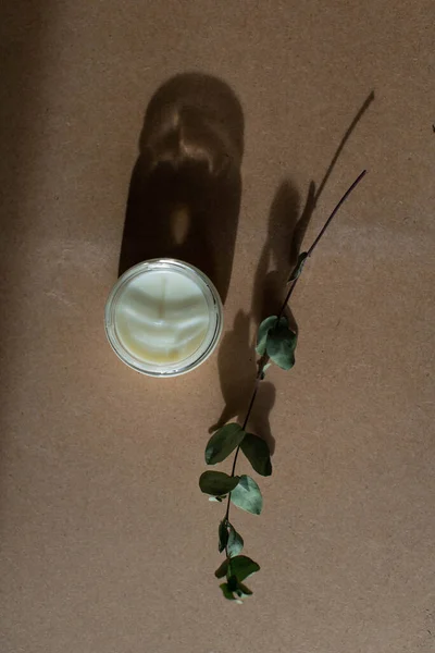 wooden wick candle. Handmade candle from paraffin and soy wax in glass with flowers and leaf on craft background. Let flay. Candle making. Top view.