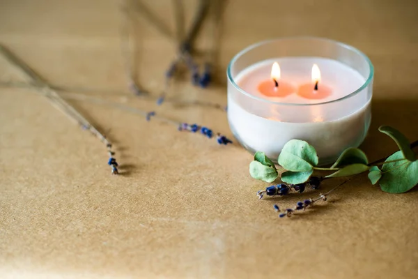 wooden wick candle. Handmade candle from paraffin and soy wax in glass with flowers and leaf on craft background. Let flay. Candle making. Top view.