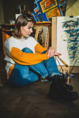 Güzel bir kadın resmi. Resim stüdyosundaki kız. Yetenekli Kadın Sanatçı Modern Soyut Yağlı Boyama, Geniş Vuruşlar Kullanarak Hareketlendirme Boya Fırçası üzerinde çalışıyor. Karanlık Yaratıcı Stüdyo