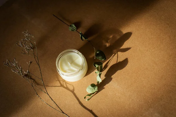 wooden wick candle. Handmade candle from paraffin and soy wax in glass with flowers and leaf on craft background. Let flay. Candle making. Top view.