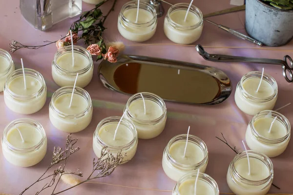 Many soy wax candles together on store or workshop background. pottery store. Ecological and vegan business. Soya wax candle accessories. Handmade with love. Remote work, online shop, workplace