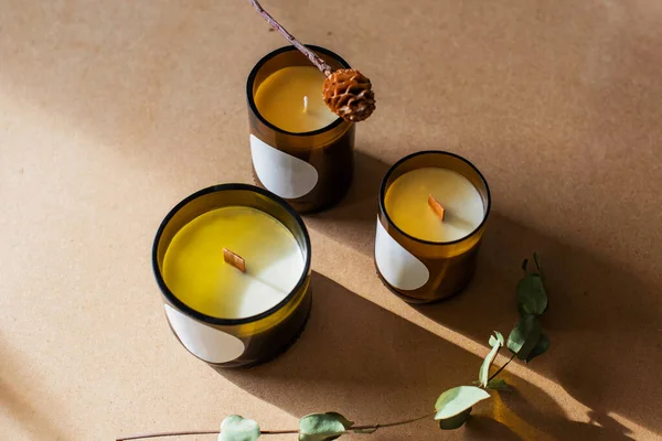 wooden wick candles. Handmade candle from paraffin and soy wax in glass with leaf on craft background. Let flay. Candle making. Top view.