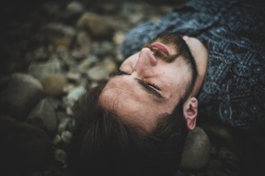 Genç, beyaz bir adam sokakta esrar tüttürüyor. Bağımlı adam iş başında. Uyuşturucu kullanımı ve trafik kavramı.