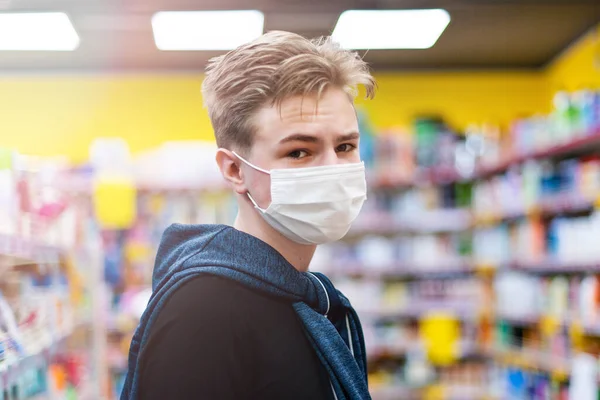 Boy wears protected mask in store. Shopping time during coronavirus outbreak.Boy in a medical mask. Quarantine and protection virus, flu, epidemic COVID-19. Coronavirus quarantine.