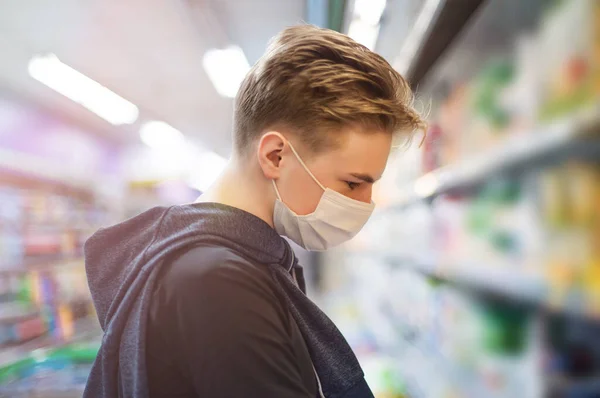 Boy wears protected mask in store. Shopping time during coronavirus outbreak.Boy in a medical mask. Quarantine and protection virus, flu, epidemic COVID-19. Coronavirus quarantine.