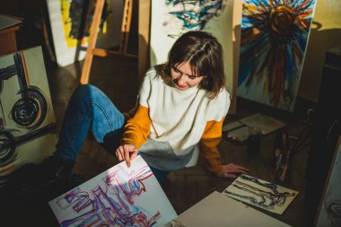 Güzel bir kadın resmi. Resim stüdyosundaki kız. Yetenekli Kadın Sanatçı Modern Soyut Yağlı Boyama, Geniş Vuruşlar Kullanarak Hareketlendirme Boya Fırçası üzerinde çalışıyor. Karanlık Yaratıcı Stüdyo