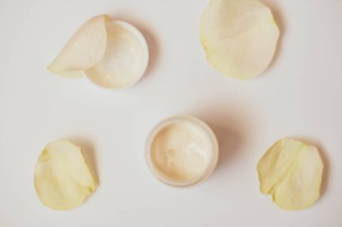 Beyaz arka planda bir kase kremalı gül, üst manzara. Ev yapımı kozmetik malzemelerinin resmi. Aroma temalı. organik kozmetik.