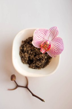 Beyaz orcgidlerin üzerine çalı kokulu gül tabağı, üst manzara. Ev yapımı kozmetik malzemelerinin resmi. Aroma temalı. organik kozmetik.