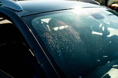 Nazik araba yıkama. Su ile kaplı modern kompakt araba. Koyu Mavi Renk Notlandırması.