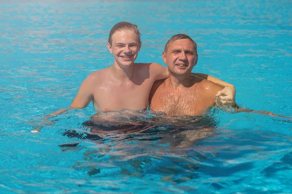 사람들은 남자와 수영을 풀장에서 즐기는 개념을 가지고 즐거운 사람들을 휴가로서 — 스톡 사진