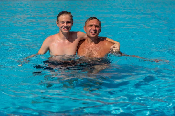사람들은 남자와 수영을 풀장에서 즐기는 개념을 가지고 즐거운 사람들을 휴가로서 — 스톡 사진
