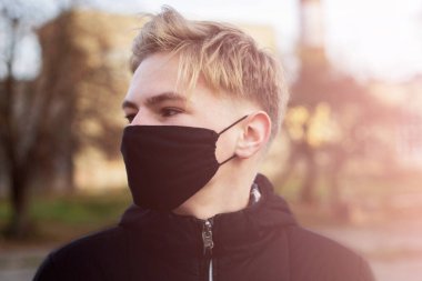 Cerrahi bandajlı tatlı bir genç çocuk. Coronavirus, hastalık, enfeksiyon, karantina, tıbbi maske, COVID-19. Tıbbi maskeli bir çocuk. Karantina ve koruma virüsü, grip, salgın COVID-19.