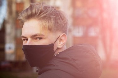 Cerrahi bandajlı tatlı bir genç çocuk. Coronavirus, hastalık, enfeksiyon, karantina, tıbbi maske, COVID-19. Tıbbi maskeli bir çocuk. Karantina ve koruma virüsü, grip, salgın COVID-19.