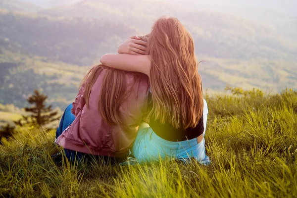 二人の友人はカルパチア山脈を見て抱擁 山の上で夕日を眺めながら二人の女の子 — ストック写真
