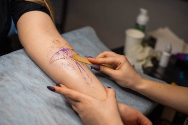 Müşterinin kolundaki geçici dövmeyi kapat. Hazırlık. Robot resmi vücuda aktar..