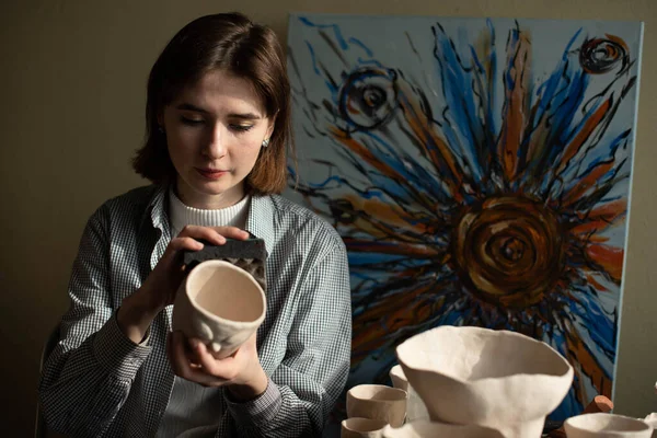 若いアーティストがアートスタジオで粘土を成形しています アーティストのスタジオで粘土彫刻から女の子の型 陶芸店で働く実業家 — ストック写真