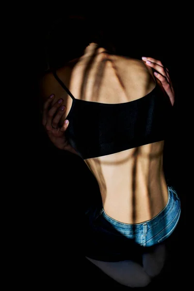 拒食症の少女に背を向けて 背骨や肋骨が見える 劇的な効果のために冷たいトーンでトーン — ストック写真