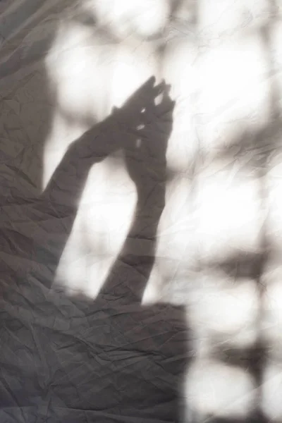 灰蒙蒙的双手在墙上互相接触 抽象模糊效果 专注于阴影 — 图库照片