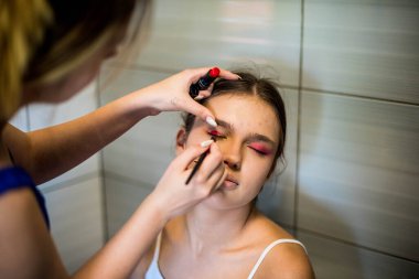 Makyaj sanatçısı arkadaşı üzerinde çalışır. Gerçek insanlar..