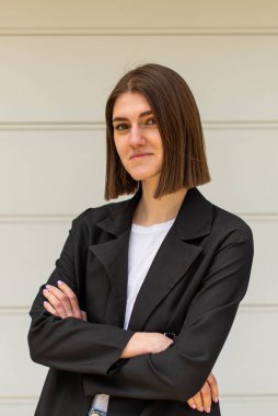 Açık havada iş kadını portresi. İş kıyafetleri içinde genç bir kız özgeçmiş çekimi için poz veriyor..