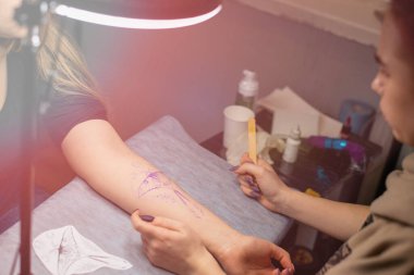 Müşterinin kolundaki geçici dövmeyi kapat. Hazırlık. Robot resmi vücuda aktar..