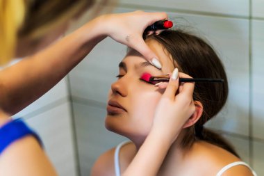 Makyaj sanatçısı arkadaşı üzerinde çalışır. Gerçek insanlar..