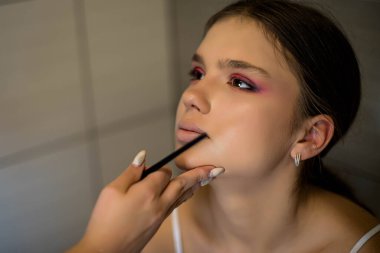 Makyaj sanatçısı arkadaşı üzerinde çalışır. Gerçek insanlar..