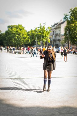 90 'ların tarzında güzel bir köylü kızı. 90 'larda 80' lerde. Retro renkli eski moda ceketli şık bir kız. Sokak tarzı kıyafetler giyip, boynunda zincirlerle yürüyüşe çıkmışlar. Gençlik ve yaşam tarzı kavramı