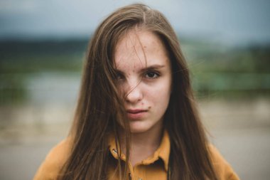 Pürüzlü ve doğal arka planda sorunlu ciltli güzel, genç bir kızın portresi. Kız gücü, vücut pozitifliği, gerçek insanlar.